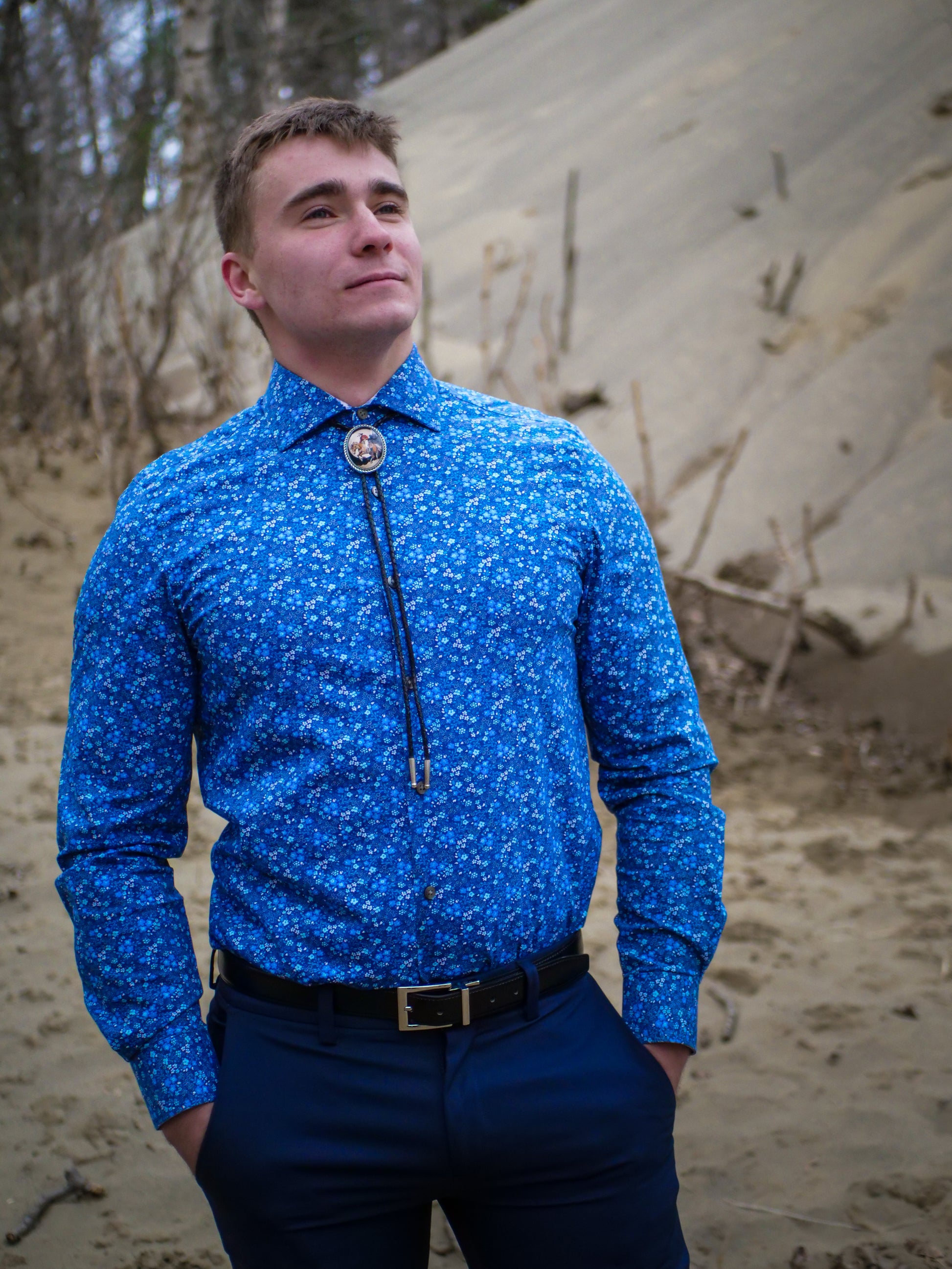 Professional bolo tie with colorful shirt, buckle, and shoes.